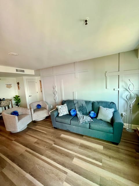 Unwind in style in the boho-chic living room featuring a designer wood accent wall, plush pillows, modern floor lamps, and lounge on our comfy sleeper sofa.