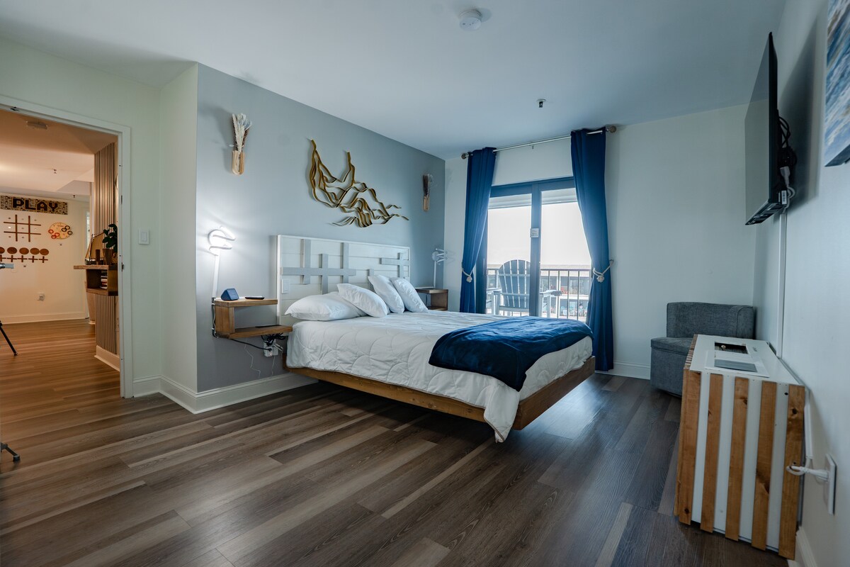 Relax in the custom-design floating queen-sized bed with motion lights, headboard, and end tables with wireless charging.