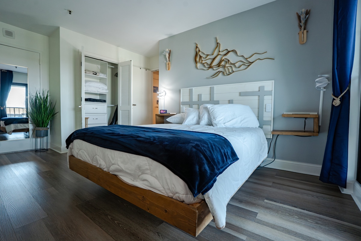 Relax in the custom-design floating queen-sized bed with motion lights, headboard, and end tables with wireless charging.