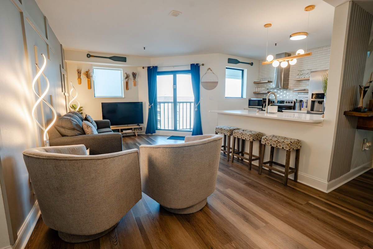 Beautiful wide-angle view of the open living and kitchen areas, featuring multiple views of the beach.