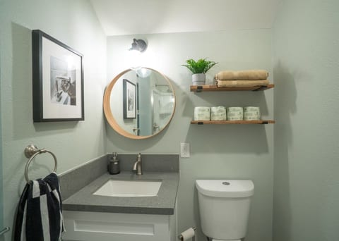 Private bathroom with glass enclosed shower.