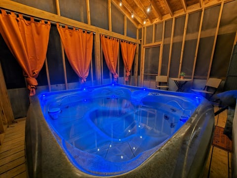 Private indoor hot tub with rustic charm and relaxing ambient lighting
