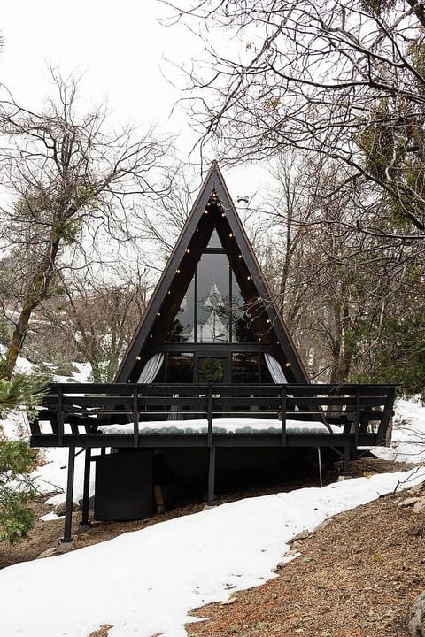 Welcome to the Tiny Triangle, a moody A-Frame cabin featured in Dwell magazine! It's a truly romantic experience, featuring a cedar hot tub, stunning boulders, a fire pit and a fireplace.
Shown: front deck, parking (left), neighbors (left & right)