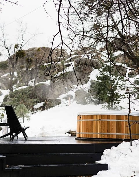 Indulge in a romantic soak in our cedar hot tub, set against majestic snowy boulders and stunning mountain views. Having a glass of wine here is the perfect ending to a day of hiking or skiing.
