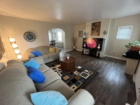 Left corner view of family room. Has comfortable chairs and 65" smart TV