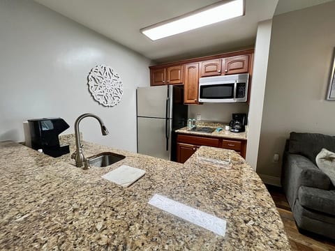 Kitchen stocked with cookware, utensils, refrigerator, stovetop, dishwasher, blender, drip and Keurig coffee makers