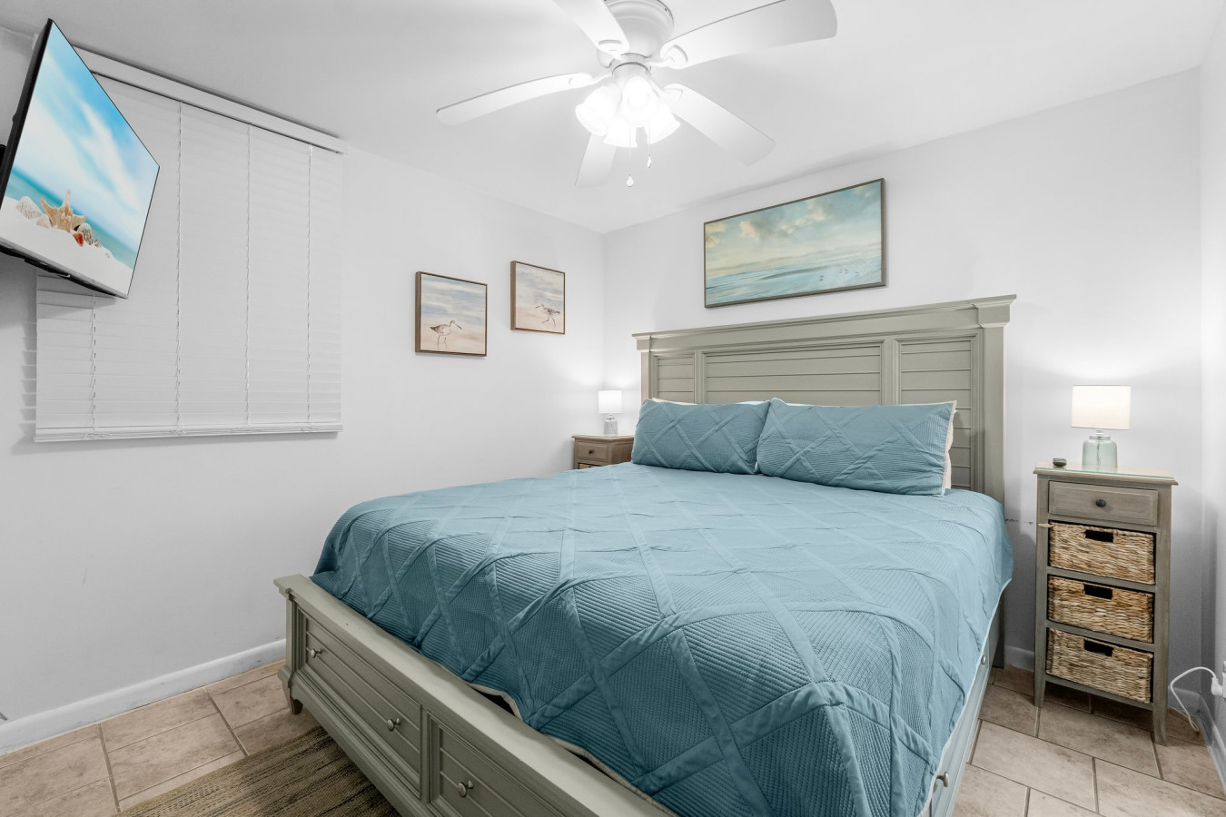 master bedroom featuring a king-size bed, beach-inspired decor, and a mounted smart TV offers the perfect retreat for relaxation.
