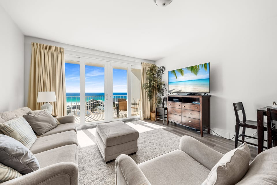 Spacious living area with comfortable seating, a sleeper sofa, a smart TV, and breathtaking ocean views from the private balcony
