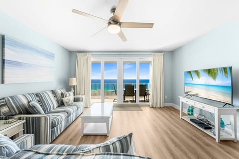 Unwind in a bright and airy living room featuring a queen-size sleeper sofa, a smart TV, and stunning ocean views through floor-to-ceiling windows leading to a private balcony