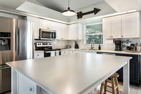 The kitchen is fully equipped for long-term stays. It includes utensils, dishes, cups, mugs, kid-friendly dishes, paper towels, a dishwasher with pods, a blender, a toaster, a fridge and freezer, pots and pans.