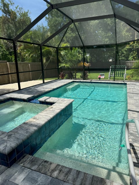 Screened heated salt pool, hot tub and patio. Includes new smart TV, patio furniture, picnic table and chaise lounge chairs.