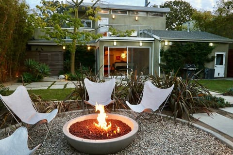 Backyard. Gas-lit fire pit. View towards dining room with sliding glass doors.