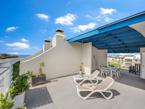A covered rooftop space with sun loungers, a dining table for 6 and a bar table to enjoy the view. Views of maroochybeach across Alex headlands, Mooloolaba and Point Cartright.