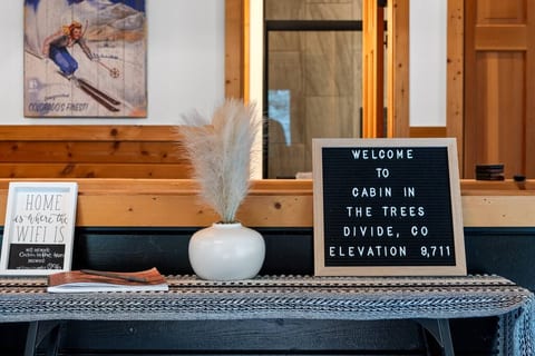 Welcome to this mountain retreat in Divide, Colorado, where the entry's charming sign greets you at an elevation of 9,711 feet. Step inside and embrace the serene ambiance of this elevated escape.