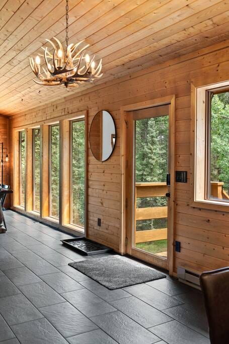 Step into the main entry, greeted by an antler chandelier and an abundance of natural light streaming through large windows. The fresh decor and remodeled interior exude a modern cabin vibe, blending rustic charm with contemporary flair.