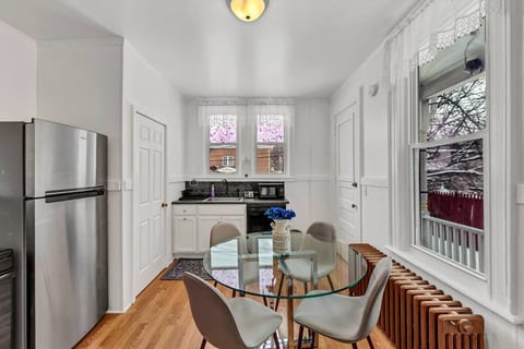 Kitchen with dining table, stove, refrigerator, microwave, keurig.