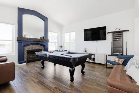 Billiards room with lounge seating & 65-in smart TV with direct patio access to the pool