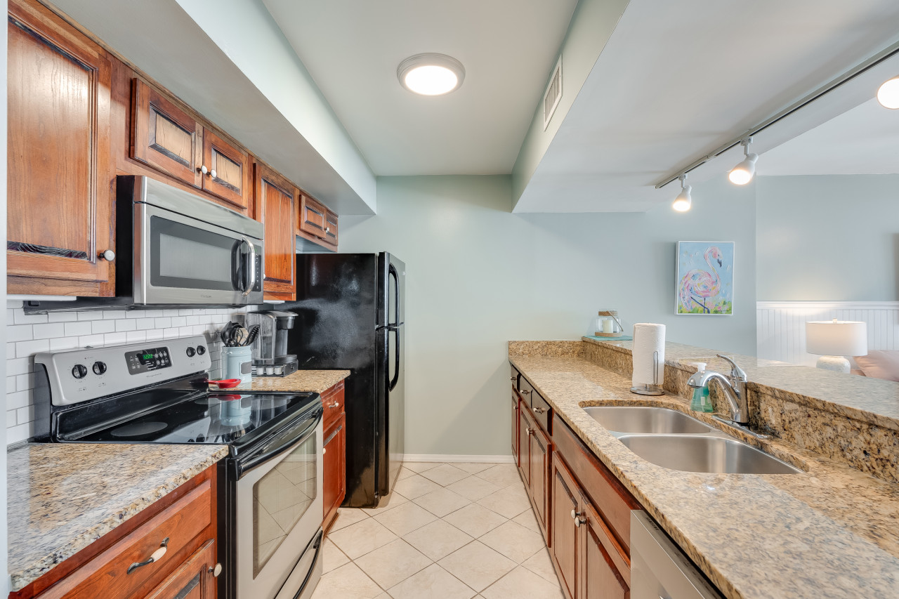Cook up coastal meals with ease in the fully equipped kitchen featuring granite countertops, stainless steel appliances, and warm wood cabinetry. Whether you're preparing a quick snack or a family dinner, this space has everything you need.