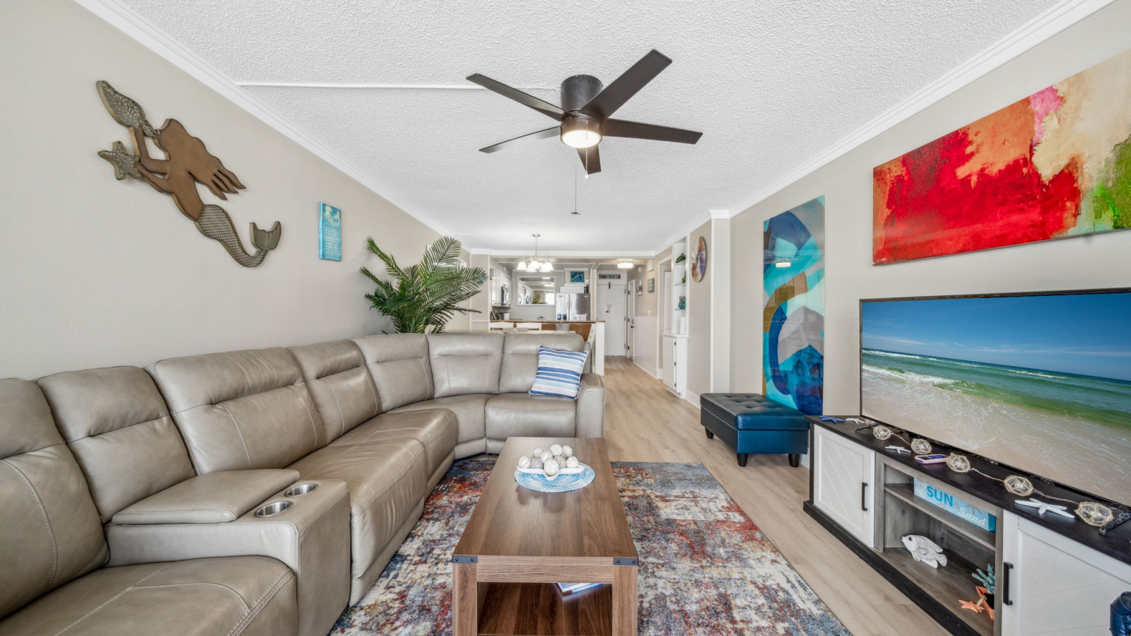 Bright beachy living room with large sectional, coastal decor, and open layout—ideal for relaxing or entertaining.