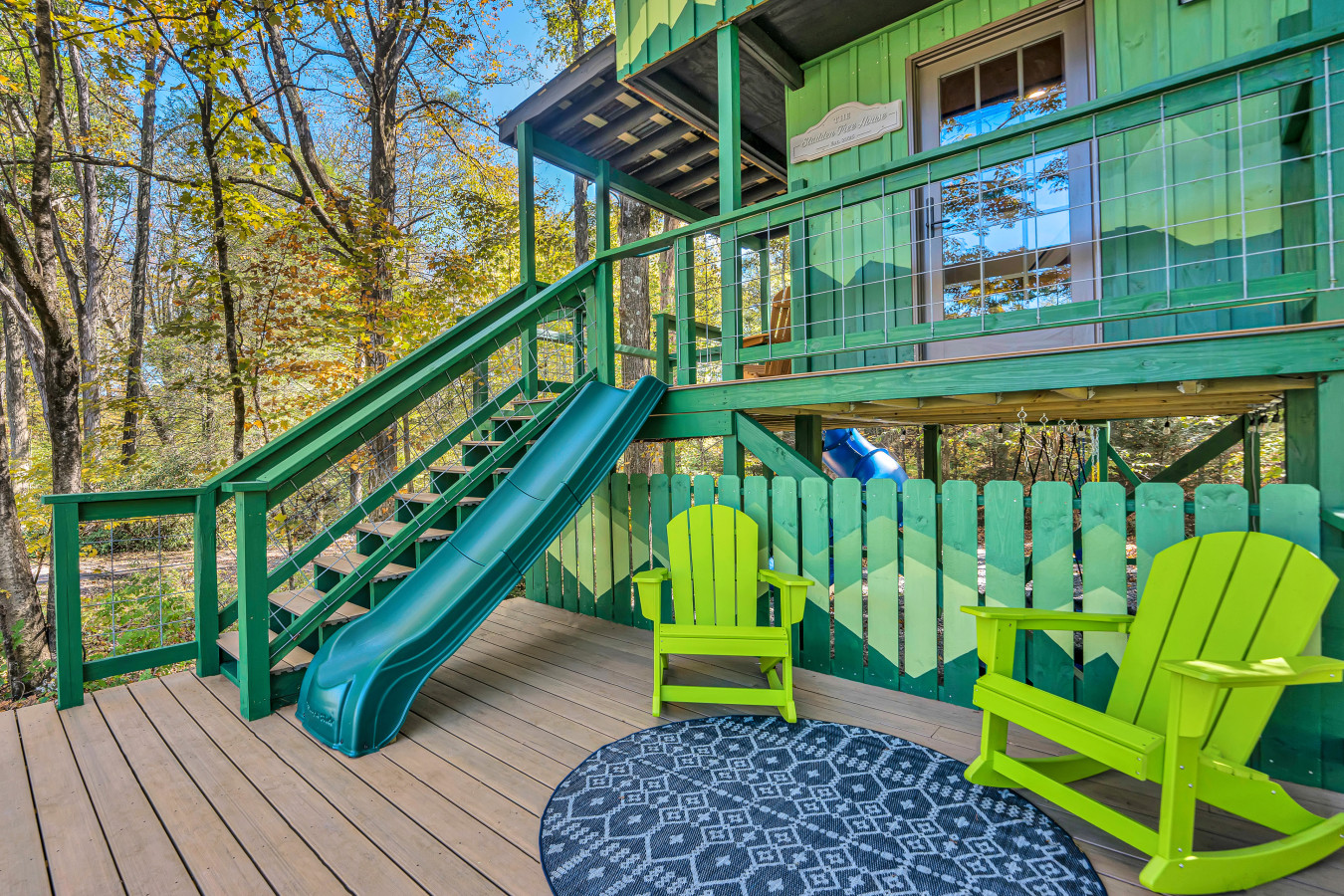 Step onto the deck of the Tree House, complete with a fun green slide — the perfect spot for both relaxation and adventure!