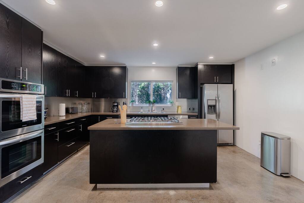 Gorgeous modern kitchen, fully stocked with a fridge and oven for crafting delectable meals throughout your visit.