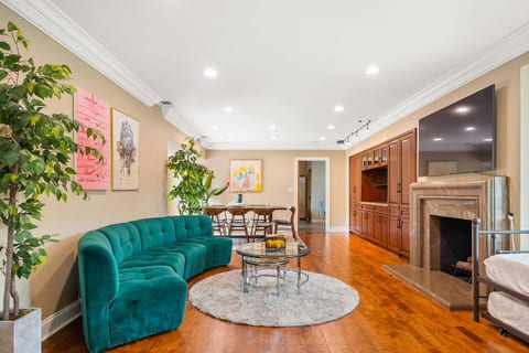 Spacious living room with a cozy and elegant green velvet sofa and large TV. Includes a twin pull-out bed, perfect for daytime relaxation or additional sleeping space.