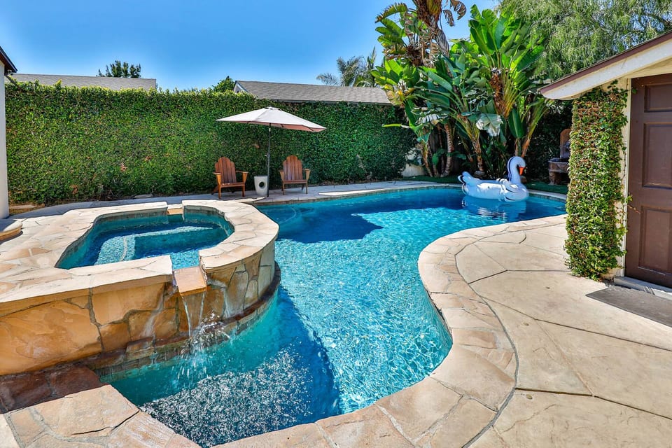 Private heated pool and spa, along with an outdoor seating area, ideal for hosting and relaxation.