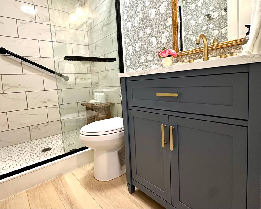 Experience historic charm and modern luxury in this stunning space, featuring exquisite English wallpaper & walk-in shower. The spa-like ambiance is elevated by the elegant new tile work, offering a boutique-style retreat perfect for a relaxing stay