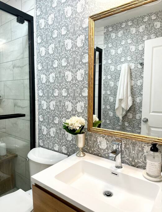 Experience historic charm and modern luxury in this stunning space, featuring exquisite English wallpaper & walk-in shower. The spa-like ambiance is elevated by the elegant new tile work, offering a boutique-style retreat perfect for a relaxing stay.