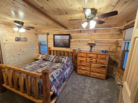 Primary bedroom with lakeview. Offers hanging closet, dresser, 2 ceiling fans and queen size bed.