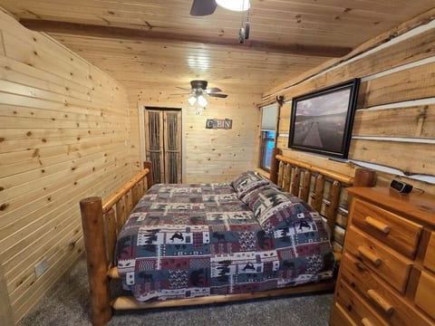 Primary bedroom with lakeview. Offers hanging closet, dresser, 2 ceiling fans and queen size bed.