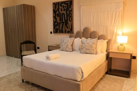 Enjoy a restful atmosphere in our bedroom adorned with paintings and luxurious wooden furniture.