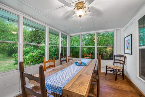 Wooden farmhouse table adds charm and functionality in sunroom!