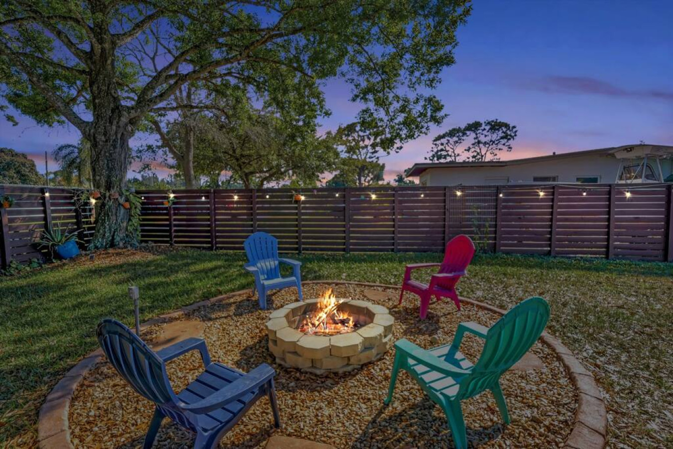 "Good times and laughter gather around the fire in this backyard haven."