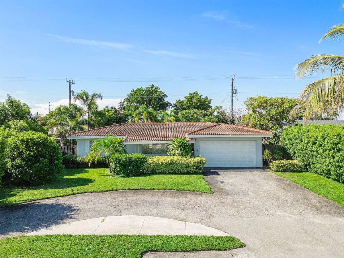 A beautiful exterior shot of the house, showcasing ample parking spots in the driveway alongside well-maintained landscaping.
