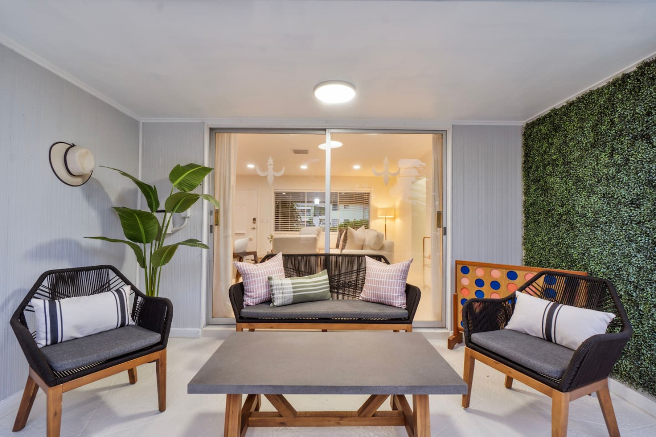 A welcoming patio featuring comfortable seating, a stylish coffee table, and lush greenery for a relaxing outdoor experience.