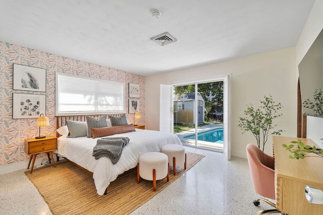 A cozy bedroom with a king-sized bed, direct access to the pool area and modern decor.
