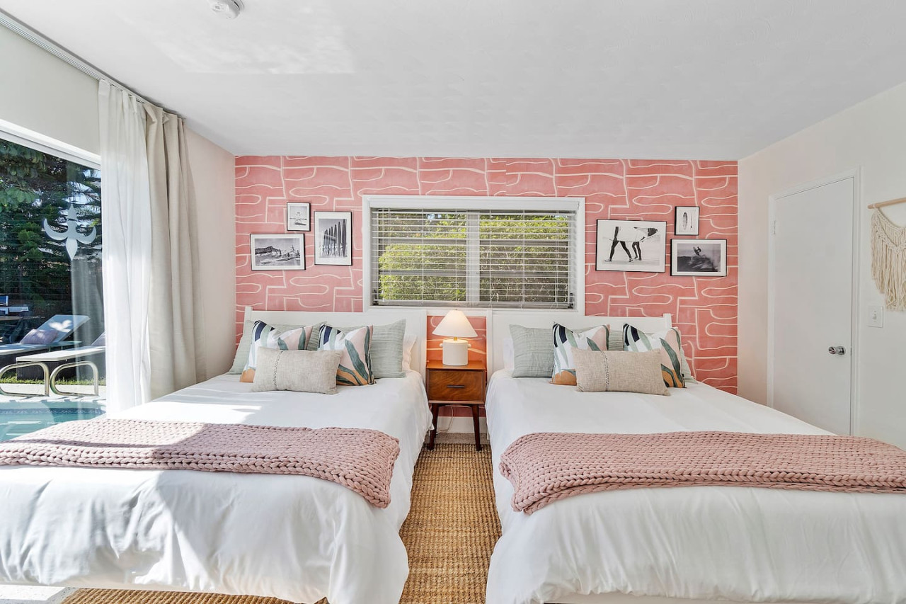 A cozy bedroom with two queen-sized beds, each with access to its own ensuite bathroom.