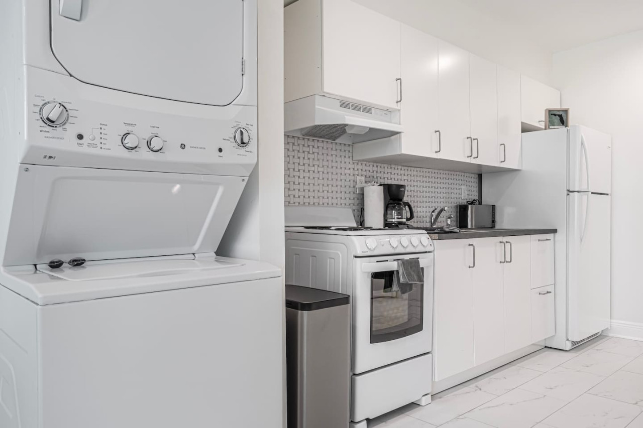 Gleaming white and neatly tucked away, this laundry room is a picture of pristine organization.