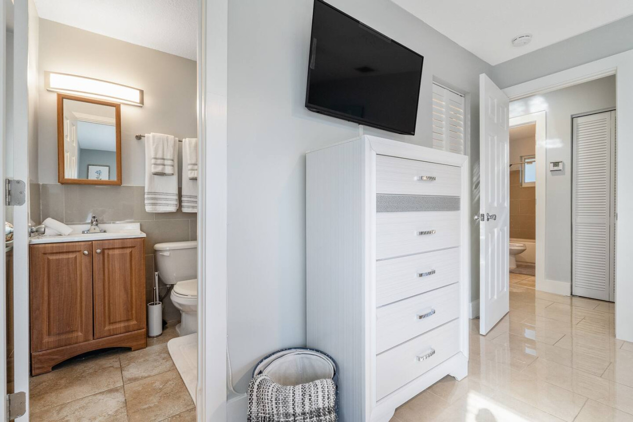 Modern farmhouse vibes with this sleek white dresser and flat screen TV