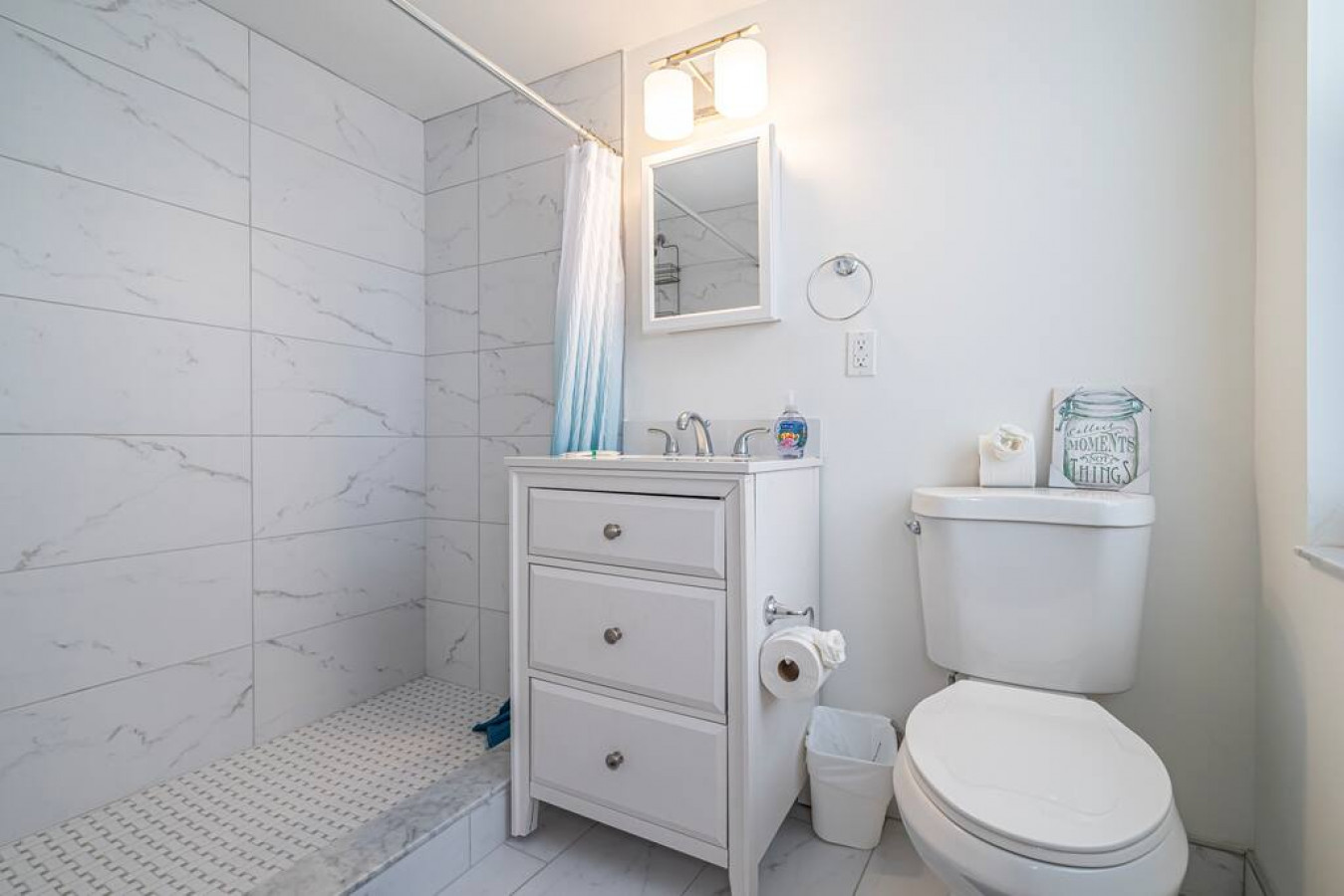 The bathroom is decorated in a minimalist style, with simple and clean-lined fixtures. The white toilet, sink, and bathtub are all in good condition and appear to be well-maintained. The walls and floors are also clean and free of any damage.