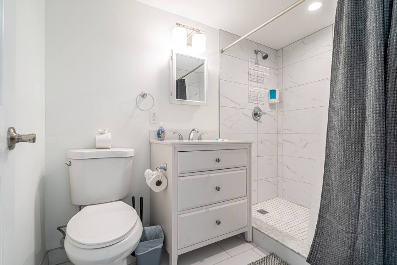 The bathroom is decorated in a minimalist style, with simple and clean-lined fixtures. The white toilet, sink, and bathtub are all in good condition and appear to be well-maintained. The walls and floors are also clean and free of any damage.