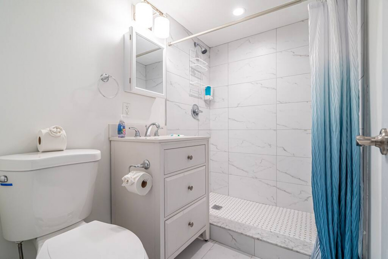The bathroom is decorated in a minimalist style, with simple and clean-lined fixtures. The white toilet, sink, and bathtub are all in good condition and appear to be well-maintained. The walls and floors are also clean and free of any damage.
