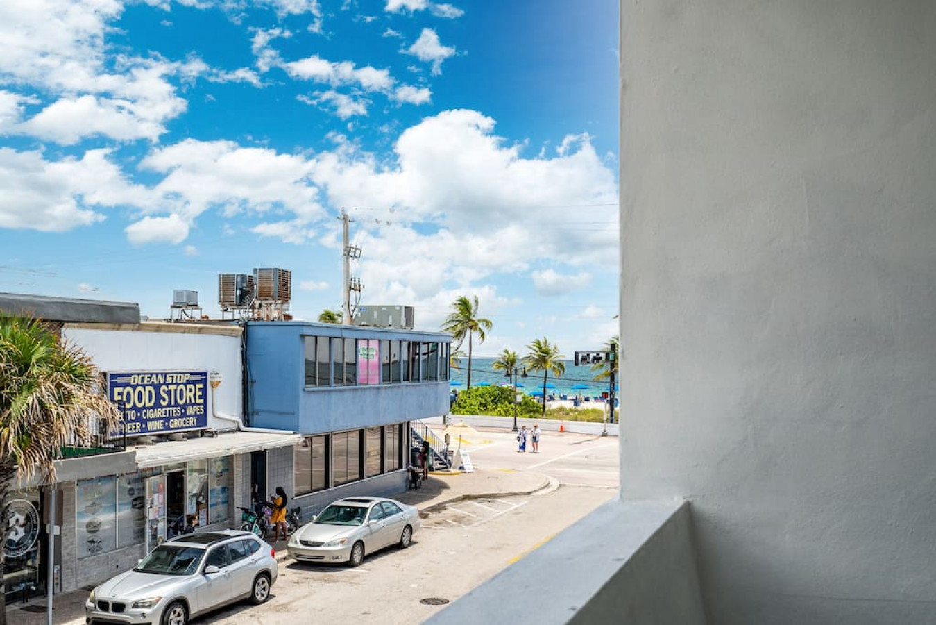 Sun-kissed rooftops and endless blue horizon: This balcony view is a postcard come to life, where the vibrant city meets the tranquil ocean in a breathtaking embrace.