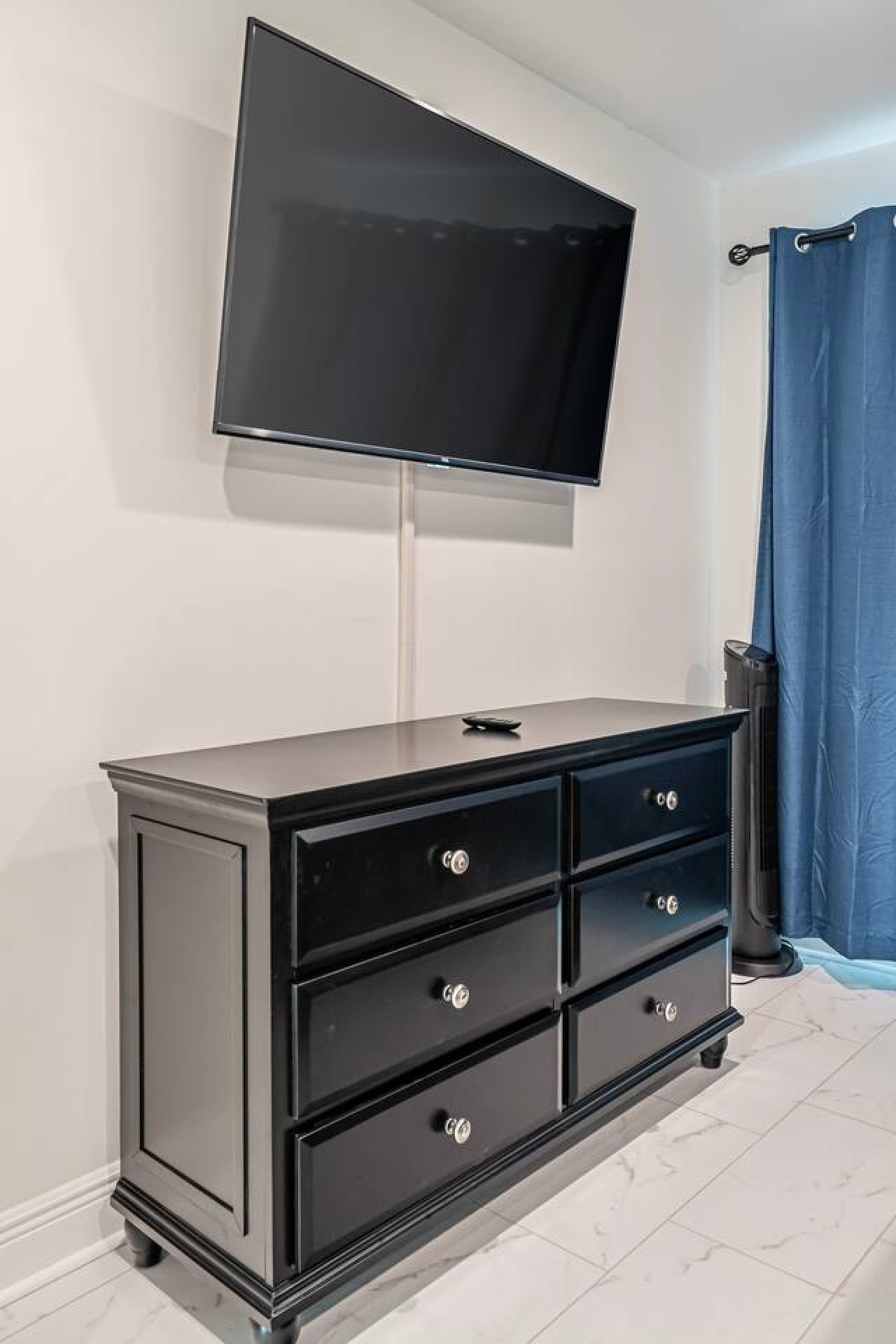 Movie night HQ: Kick back and relax in this inviting living room, complete with a big-screen TV, plush couch, and cozy ottoman for putting your feet up.