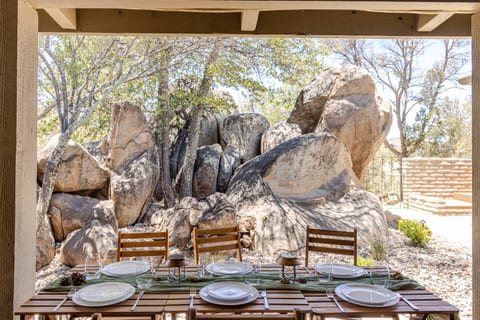 Candles glow against the boulders as dinner stretches long past sunset. You linger at the table, pouring another glass, passing plates, laughing at stories—already imagining how good it feels to stay just a little longer under the night sky.