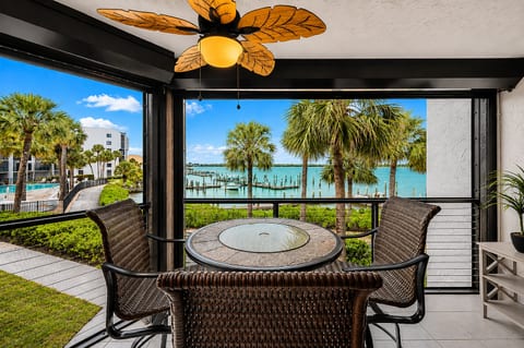 Screened waterfront balcony with tropical views and outdoor dining
