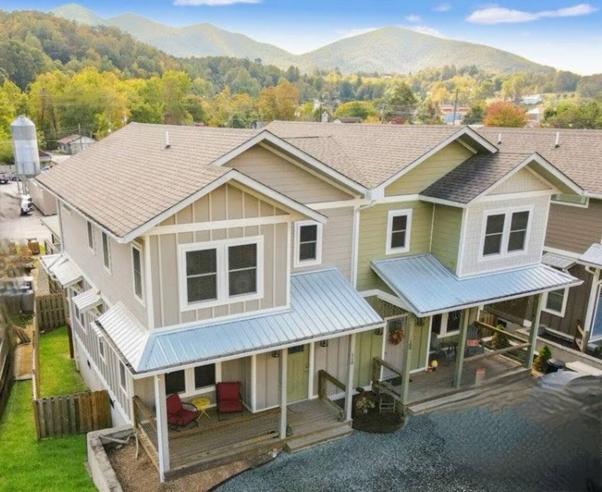 Exterior view of the home with a small front porch and outdoor furniture, with the entry located on the left side of the house.