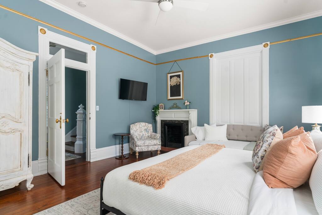 A gorgeous antique armoire and separate seating area adds to the charm of this bedroom. 