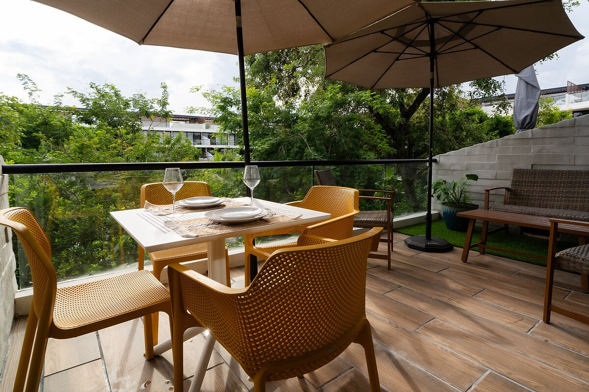 Enjoy your morning coffee on this charming balcony with cozy wicker seating and lush greenery. Perfect for a serene urban retreat, this private outdoor haven offers modern amenities and a peaceful view, making it an ideal spot to unwind.”
